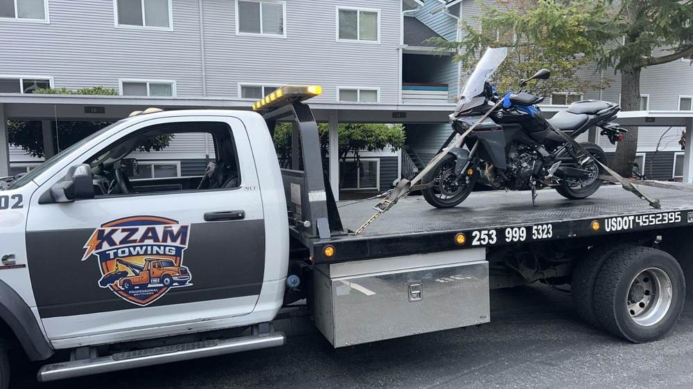 KZAM flatbed loading a Ford F-150