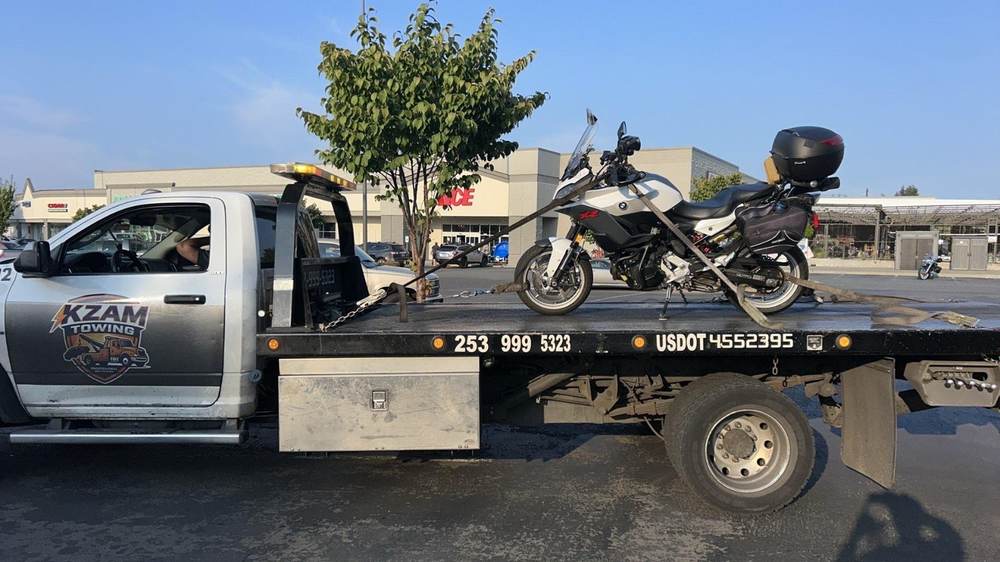 KZAM flatbed towing a vehicle